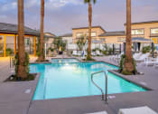 Thumbnail 4 of 68 - a swimming pool with palm trees and chairs around it at Grandstone at Sunrise, Peoria, AZ, 85383